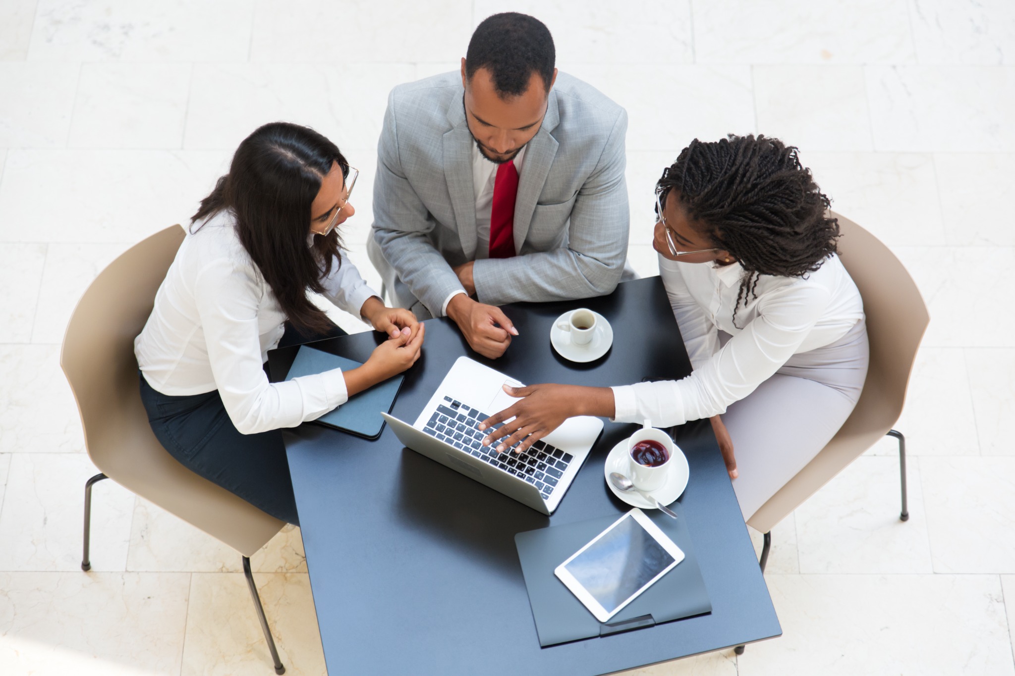 African professionals collaborating around a laptop